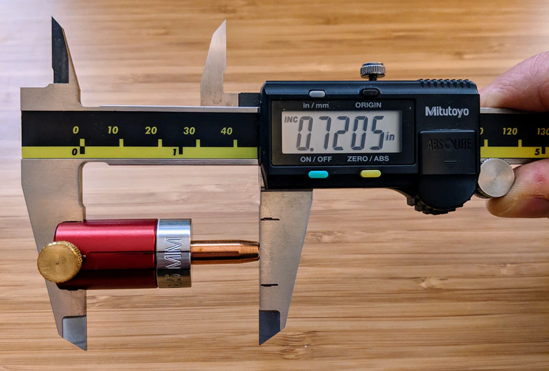 Checking the bullet’s base-to-ogive length with a single comparator.